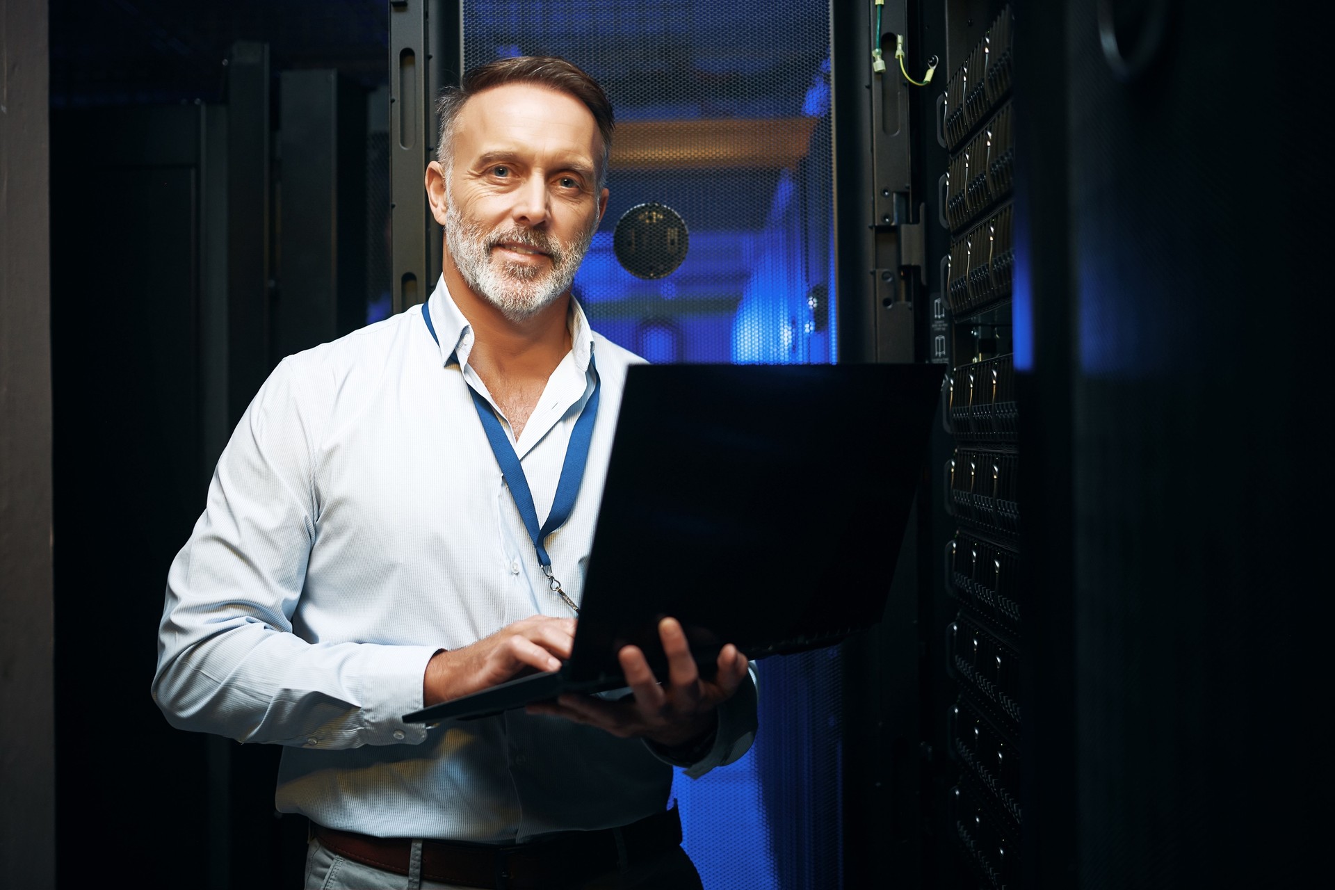 Portrait of a mature man using a laptop while working in a server room